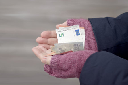 Woman wearing gloves holding euro banknotes and coins. High quality photoの写真素材