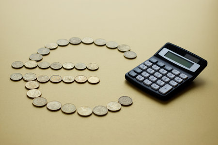 Euro symbol made of coins with calculator on light backgroundの写真素材