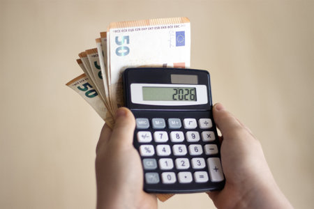 Child calculating money using a calculatorの写真素材