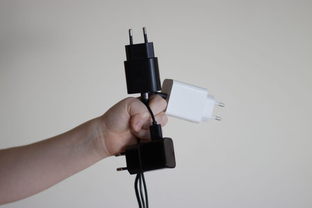 Hand holding charging adapters and cables