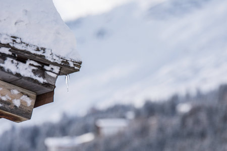 Icicle on a snowy roof during winterの写真素材