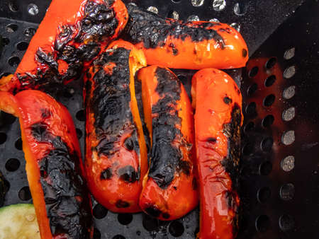 View of grilled and roasted peppers and vegetables on barbeque as a part of a meal in outdoor settingの写真素材