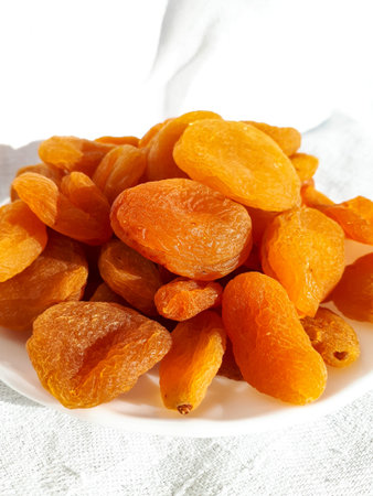 Dried apricot group on a white plate on a white background