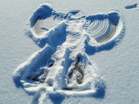 Snow angel in the snow in winter on a sunny dayの写真素材