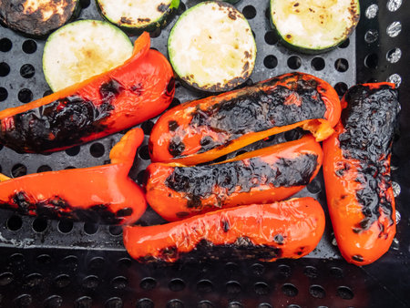 View of grilled and roasted peppers and vegetables on barbeque as a part of a meal in outdoor settingの写真素材