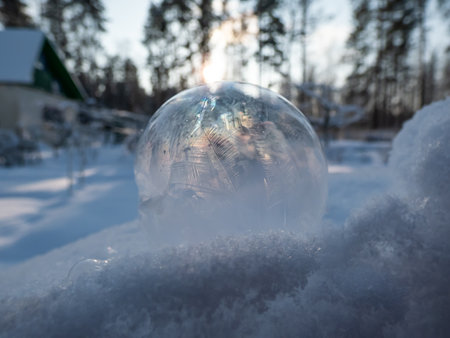 Macro shot of round, frozen soap bubble forming beautiful leaf and tree like pattern while freezing in very cold temperatures in winterの写真素材