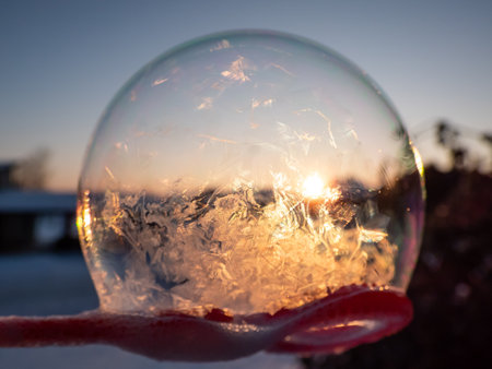 Macro shot of round, frozen soap bubble forming beautiful leaf and tree like pattern while freezing in very cold temperatures in winterの写真素材