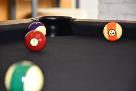 The pocket or hole of a billiard table that is covered with black billiard cloth balls are out of...