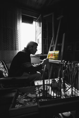 Paint artist at home studio, working on his new picture.の写真素材