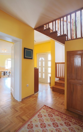 Entrance hall of a modern house, view on rooms and wooden stairs. の写真素材