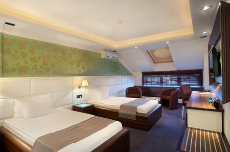 Interior of a hotel room for two, two beds and green wallpapers. の写真素材