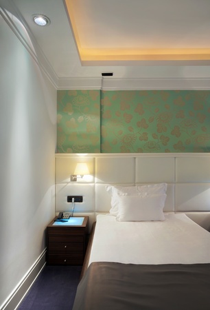 Interior of a hotel room for two, a bed and green wallpapers. の写真素材