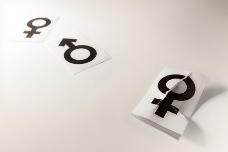 Illustrative concept of a abandoned woman, presented by white papers with gender symbols printed on it  の写真素材