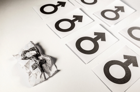 Concept of abused woman illustrated by white papers with gender symbols printed on it  の写真素材