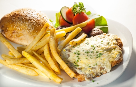 Piece of fried meat and fries on white plate, studio isolated  の写真素材