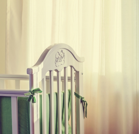 Details of a bed for babies, white curtain in the background.の写真素材