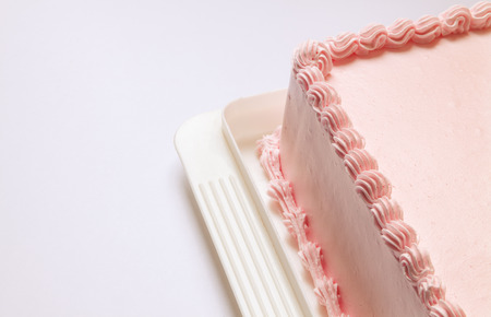 Pink birthday cake, part of it, a view on material and details of cream  の写真素材