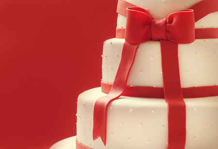 Details of wedding cake, decorated with red sugar ribbons  の写真素材