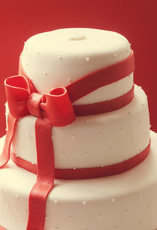 Details of wedding cake, decorated with red sugar ribbons  の写真素材