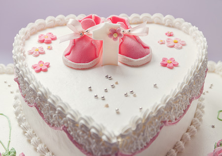 Details of a birthday cake for baby girl, number one and sweet sugar shoes on top.の写真素材