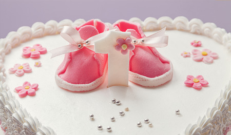 Details of a birthday cake for baby girl, number one and sweet sugar shoes on top.の写真素材