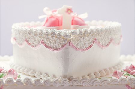 Details of a birthday cake for baby girl, number one and sweet sugar shoes on top.の写真素材