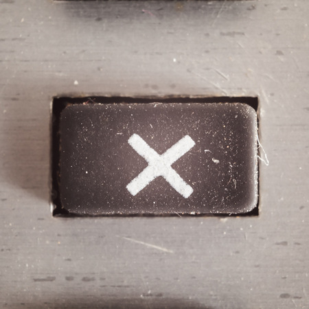 Old dirty and dusty rubberized button with written math symbol on it, part of an old calculator.の写真素材