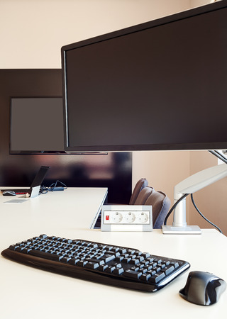 Interior of a modern office, furniture in white and computer hardware on table.の写真素材
