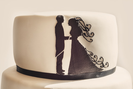 Details of a wedding cake, white sugar cream and black silhouettes.の写真素材