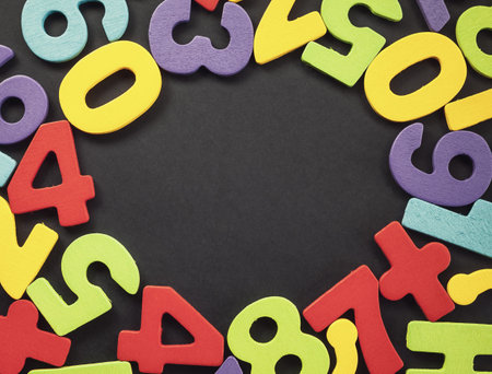 Various colorful wooden numbers all around center, empty space in the middle.の写真素材