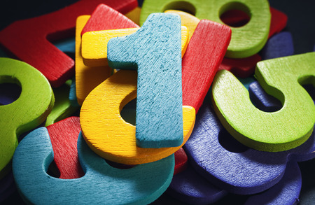 Bunch of wooden numbers, number one on top.の写真素材