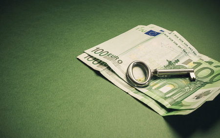 Conceptual composition euro hundred banknotes with key as symbolic object.