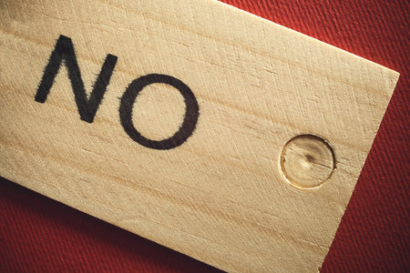 Word no written on wooden tile red textured background.