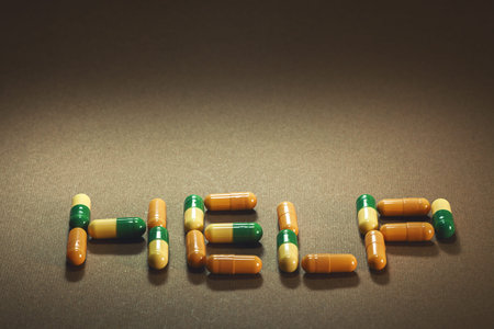Word help written with pills, blurry brown background.の写真素材