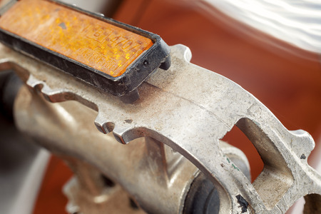 Part of a bicycle, detail of a pedal, bright orange part called cat eye.の写真素材