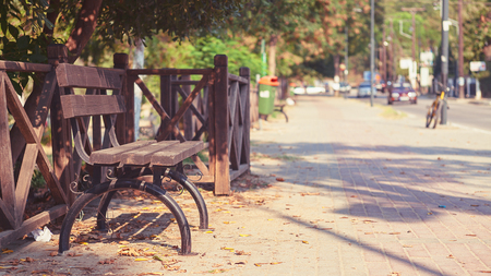 Details of a wooden bench in Stavros town, Greece. During summer season, street in background.の写真素材