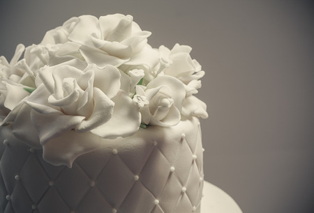 Details of a wedding cake, decoration with white fondant on white background.の写真素材