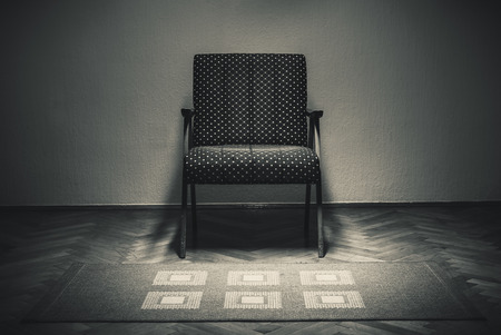 Old armchair and carpet in empty room, in white and black retro style.の写真素材