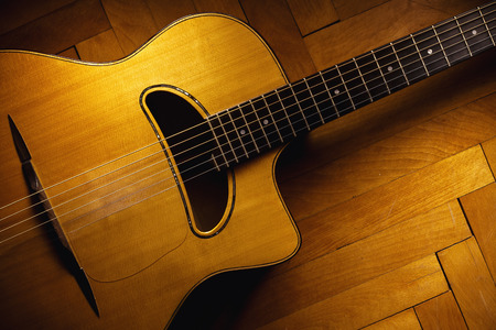 Old gypsy acoustic guitar on parquet floor.の写真素材