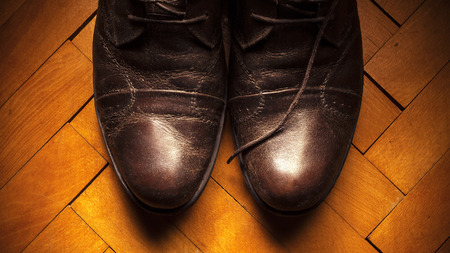 Male leather shoes on parquet, retro style.の写真素材