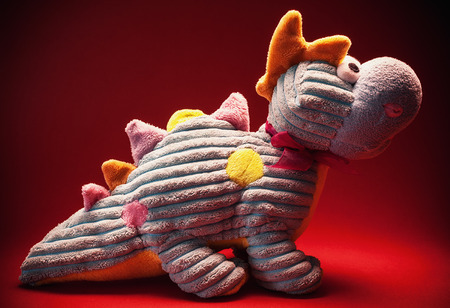 Dinosaur toy, colorful plush, on red background.の写真素材
