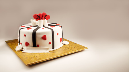Anniversary cake decoration with red hearts and black ribbons.の写真素材