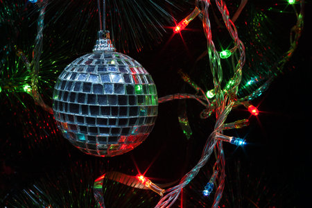 Details of Christmas tree decorated ornaments, partially illuminated.