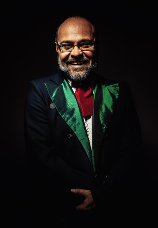 Studio portrait of an older beard man, looks like an artist, conductor or something similar.の写真素材