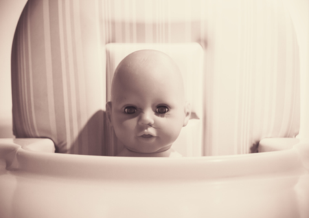 Head of baby doll in pale colors, ready for lunch.の写真素材