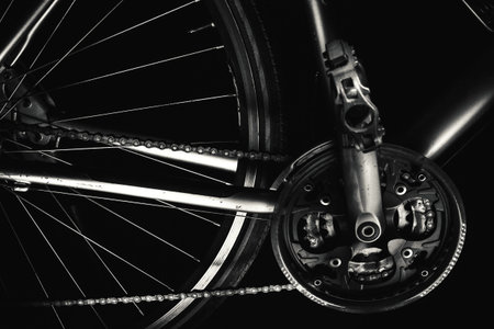 Part of a sport and modern bicycle in dark, accentuated shapes with lights.