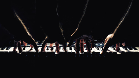 Playing a keyboard, left and right double hands, accentuated contrasts.の写真素材