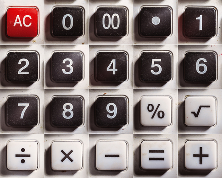 Numbers and mathematical signs of an old dusty calculator.の写真素材