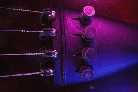 Studio composition of an old dusty violin, blue and purple illumination from aside, closeup view on...