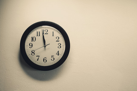 Details of a dusty clock on the white wall, retro style.の写真素材